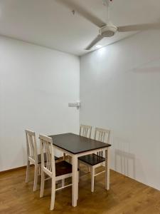 a table and chairs in a room with a white wall at Make Memories Escape 2BR Stay Summer Mall in Kota Samarahan