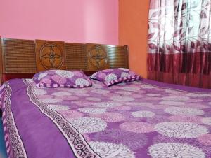 a purple bed with two pillows on top of it at Hotel Al-Hayat Abasik in Dhaka