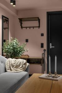 a living room with a couch and a table with two candles at Tromsø Studio - in the heart of the city in Lii