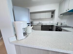 una cucina con macchinetta del caffè su un bancone di Odeon Ocean View a Strand Altre 20 foto