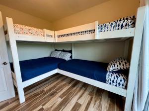 1 dormitorio con 2 literas con sábanas azules en Family Tides on LGI - Golf Cart Included, en Placida
