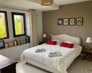 een slaapkamer met een wit bed met twee handdoeken erop bij Beautiful house Ciboure pool designed in Ciboure