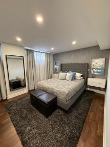 a bedroom with a large bed and a mirror at Modern Retreat with Hot tub by YYZ, 20min to CN Tower in Toronto