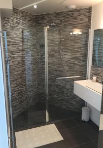 een badkamer met een douche met een glazen deur bij Beautiful house Ciboure pool designed in Ciboure +12 foto's