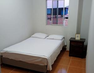 ein Schlafzimmer mit einem weißen Bett und einem Fenster in der Unterkunft Vasco Peruano House in Jaén + 5 Fotos