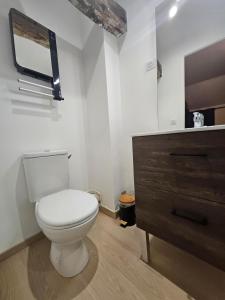 a bathroom with a toilet and a wooden dresser at Murmures de la Risle in Pont-Audemer +2 photos