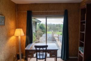 a room with a table and chairs and a window at Maison Percheronne by Green Folies, 15p & piscine in La Gaudaine
