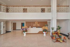 a lobby with a waiting area with flowers in vases at Lyns Hotel in Nhơn Trạch