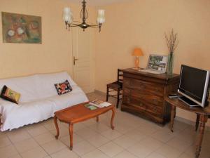 Una sala de estar con un sofá y un escritorio con televisión. en Gîte lumineux, en Antaignagues