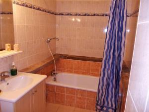 y baño con bañera, lavamanos y cortina de ducha. en Gîte lumineux, en Antaignagues 3 fotos más