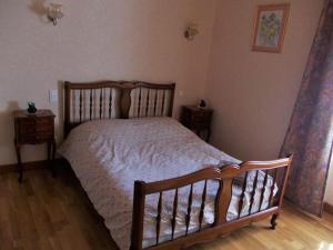 Un dormitorio con una cama de madera y dos mesitas de noche. en Gîte lumineux, en Antaignagues