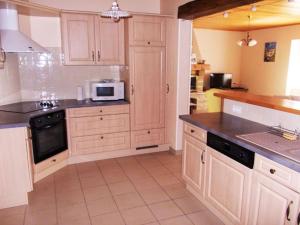 Una cocina con gabinetes blancos y un microondas. en Gîte lumineux, en Antaignagues 4 fotos más