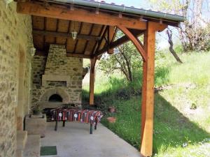 Un pabellón con un horno de piedra y un banco debajo. en Gîte lumineux, en Antaignagues