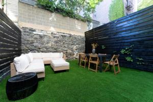 a patio with a white couch and a table on grass at Newly Renovated 2BR w Backyard in New York