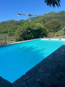 a blue swimming pool with a mountain in the background at Rosa dei Venti in Rapallo