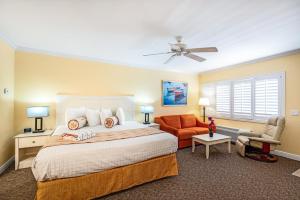 a bedroom with a bed and a chair and a ceiling fan at Inn at the Beach-Venice FLORIDA in Venice +57 photos