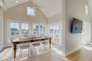 una sala da pranzo con tavolo, sedie e finestre di South Bethany --- 102 Brandywine Dr a Bethany Beach