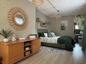 Un dormitorio con una cama, una cómoda y un espejo. en NBs Sage & Stone Nest, en Edenvale 16 fotos más