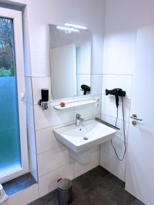 NEU "Poseidon" Papenburg ebenerdig rollstuhlgerecht 84 qm Neubau EBK Free Wifi NEU في بابينبورغ: حمام أبيض مع حوض ومرآة +31 صورة