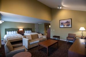 a hotel room with a bed and a living room at The Bard's Inn - BW Signature Collection by Best Western in Ashland