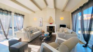 a living room with white furniture and a fireplace at Superbe villa avec piscine dans le village de St Clément in Saint-Clément-des-Baleines