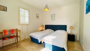 a bedroom with two beds and a window at Superbe villa avec piscine dans le village de St Clément in Saint-Clément-des-Baleines +6 photos