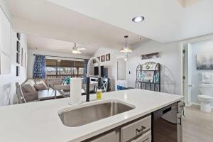 a kitchen with a sink and a living room at Ozark Overlook Escape - For 6 in Branson West +15 photos
