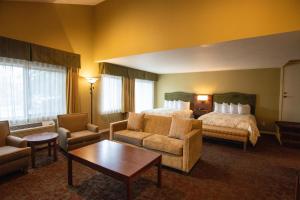 a hotel room with a bed and chairs and a table at The Bard's Inn - BW Signature Collection by Best Western in Ashland