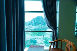 a room with a window with a view of a river at Brother Hotel & Travel in Cat Ba