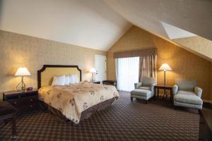 a hotel room with a bed and two chairs at The Bard's Inn - BW Signature Collection by Best Western in Ashland