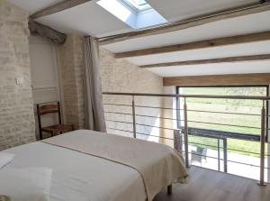 ein Schlafzimmer mit einem Bett und einem großen Fenster in der Unterkunft Gite La Ferme - Les Gites Du Moulin in Saint-Hilaire-la-Palud