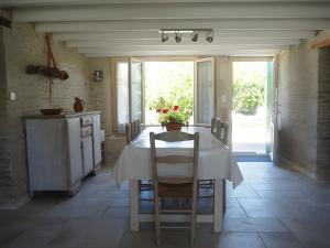eine Küche mit einem weißen Tisch und Stühlen sowie einem Fenster in der Unterkunft Gite La Ferme - Les Gites Du Moulin in Saint-Hilaire-la-Palud