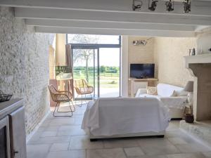 ein Wohnzimmer mit einem Bett und einem Kamin in der Unterkunft Gite La Ferme - Les Gites Du Moulin in Saint-Hilaire-la-Palud