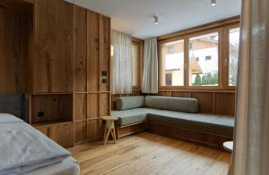 una camera da letto con divano e finestra di Sarti Apparment a San Candido