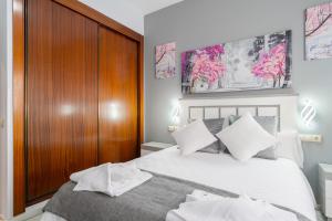 a bedroom with a large white bed with a wooden headboard at Apartamento Deluxe 1 Room Piscina Parking LuxSevilla Bormujos in Bormujos +47 photos