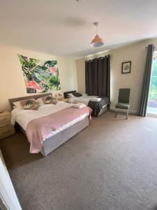 a bedroom with two beds and a chair at 4 Bedrooms, 3 Bathrooms, Comfy beds, 5 Netflix TVs & VAN PARKING in Boston