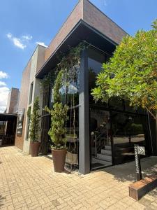 a building with glass doors and potted trees outside at Hotel Flores de Holambra in Holambra