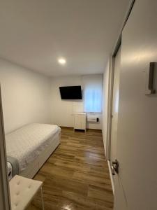 Ribera y Gastronomía في اراندا دي دويرو: غرفة نوم صغيرة بها سرير وتلفزيون