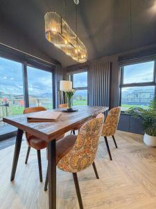 een eetkamer met een houten tafel en stoelen bij Blackthorn Timber Lodge in Bothel