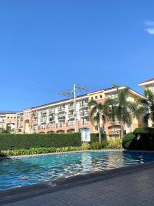 a large apartment building with a pool in front of it at 1 Bedroom Arezzo Condotel in Davao City