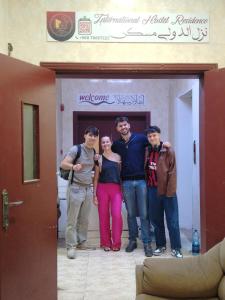 un grupo de personas de pie delante de una puerta en INTERNATIONAL HOSTEl, en Mascate