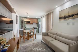 Apto a 750m do Mar c/ varanda e churrasq. GVT2105 في ميا برايا: غرفة معيشة مع أريكة وطاولة