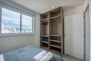 Apto a 750m do Mar c/ varanda e churrasq. GVT2105 في ميا برايا: غرفة نوم بها سرير ونافذة كبيرة