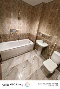 Un baño con bañera, inodoro y lavabo. en Pyramids zh inn, en El Cairo