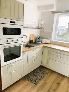 a kitchen with a white stove and a sink at L'Ecrin Marin Centre historique Plage à 5 min in Le Croisic