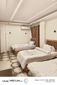 una habitación de hotel con 3 camas. en Pyramids zh inn, en El Cairo