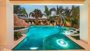 a swimming pool in a resort with palm trees at Sunset Lagoon Estate in Siesta Key
