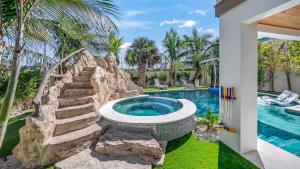 a swimming pool with a stone staircase next to a house at Sunset Lagoon Estate in Siesta Key