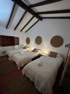 drie bedden in een kamer met verlichting aan de muur bij Ohana Villa Paula in Huertas del Palmar