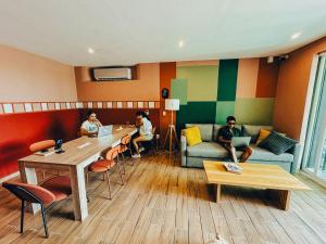 a group of people sitting at a table in a room at Viajero Bacalar Hostel in Bacalar